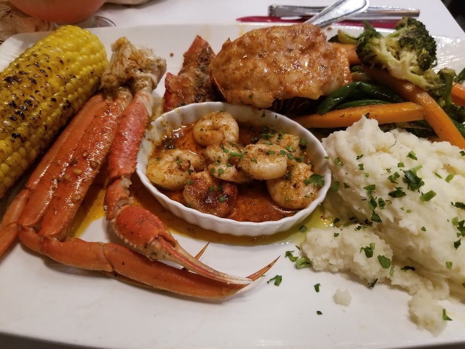 Mixed seafood dishes served family-style on a table.